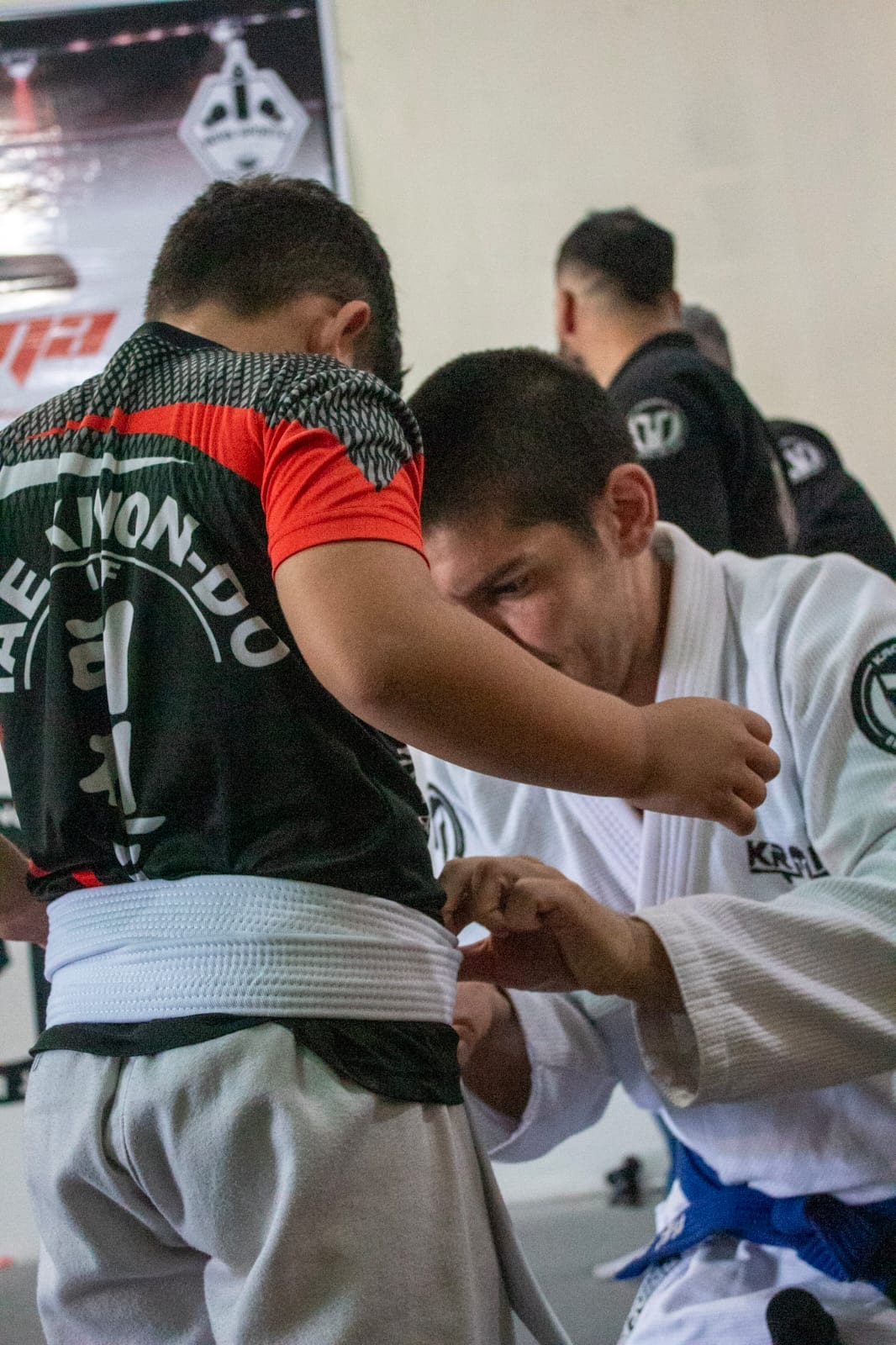 Instructor de A J Contact ajustando el cinturón de un alumno